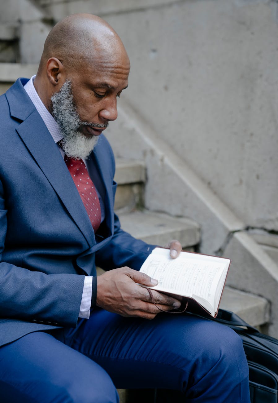 Distinguished man in his late 50s reading in a well-designed living room